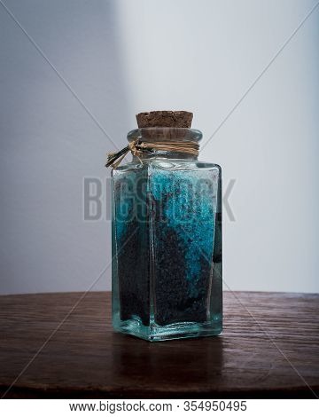 Fancy Bottle With Blue Bath Salts For Relaxing Spa Treatments With White Background