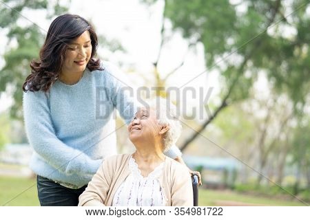 Help And Care Asian Senior Or Elderly Old Lady Woman Patient Sitting On Wheelchair At Park In Nursin