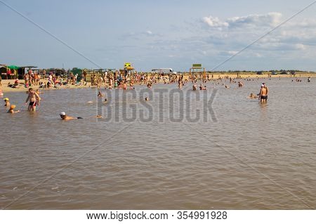 Arabat Spit, Ukraine - August 23, 2017: Unknown People Bathe In The Salt Lake. Composition Of The Wa