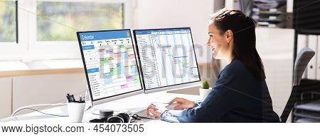 Employee Working On Calendar Schedule And Staff Time Sheet