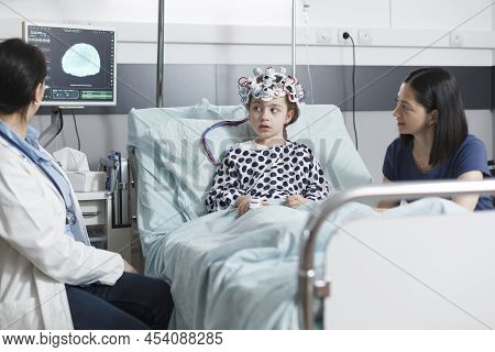 Pediatric Medic Analyzing Electroencephalogram Scan Results Of Unwell Little Girl While In Pediatric
