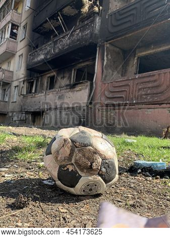 Courtyard Of A Destroyed Multi-storey Building After An Airstrike. Soccer Ball On The Background Of