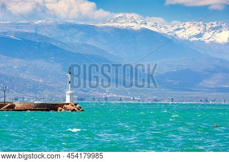 Lighthouse And Snow Mountain Peaks In Nafplio Or Nafplion, Greece, Peloponnese