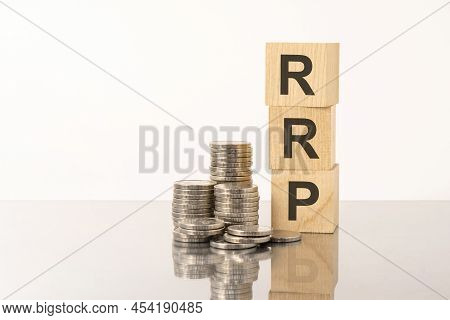 Rrp - Text On Wooden Cubes On White Background With Coins