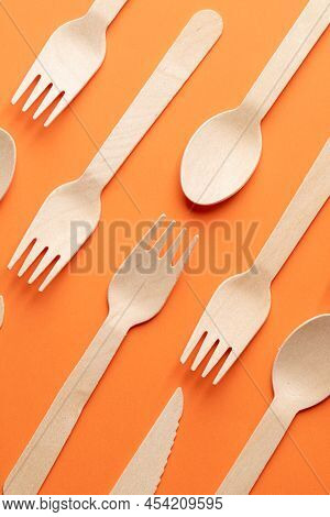 Disposable Wooden Cutlery On A Orange Background. Environmentally Friendly Materials.