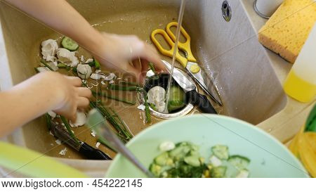 Organic Garbage In Sink With Built-in Food Waste Disposer. Vegetable Or Fruits Peels, Remains And Le