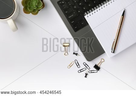 Top View Of Working Place With Grey Laptop With Black Buttons And A White Notebook On It, Gold Color