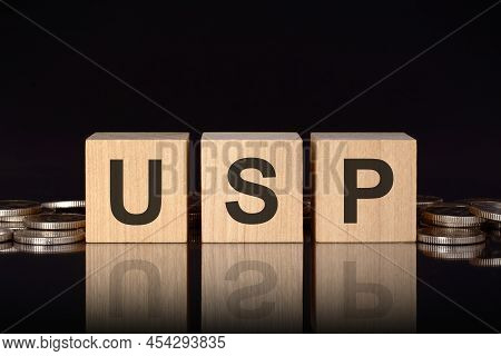 Usp - Short For Unique Selling Proposition. Text On Wood Cubes With Coins, Black Background, Busines