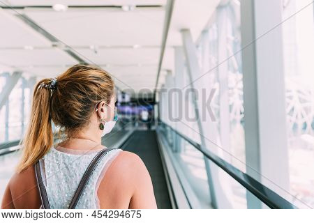 Young Woman In Mask Walks On Travolator At Shopping Mall. Young Adult Caucasian Woman Moving On Trav