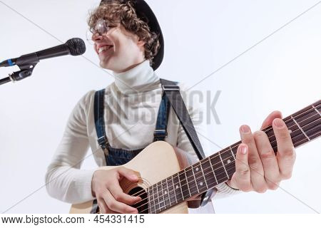 Portrait Of Young Emotiona Man, Musician Playing Acoustic Guitar And Singing. Concept Of Art, Music,