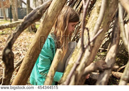 Young Adolescent Girl Outside In The Forest With Lean-to Tree Fort Treehouse Tree House She Built