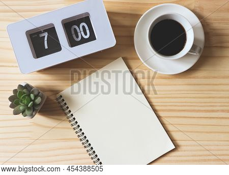 Top View Or Flat Lay Of Empty Page Notebook With Flip Clock 7 Am,  A Cup Of Black Coffee And Succule