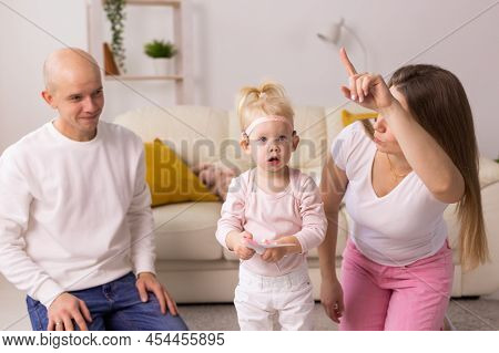 Cochlear Implant On The Child Girl Head And Playing With Mother And Father. Hearing Aid And Deafness