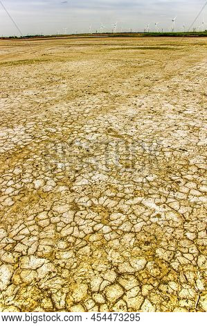 Close-up Of A Cracked Ground Of A Dried Lake On Steppe Near The Windmill Farm, Ukraine