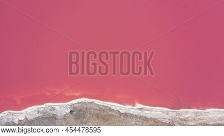 Flying Over A Pink Salt Lake. Salt Production Facilities Saline Evaporation Pond Fields In The Salty