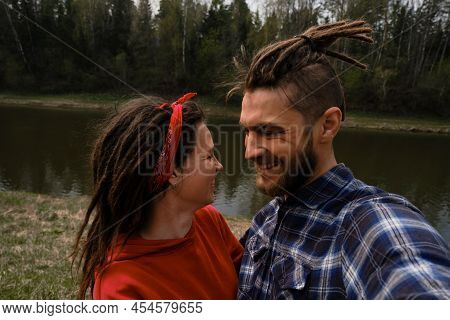 Concept Of Support And Family Values. Young European Couple, Man And Woman With Dreadlocks Hug And T