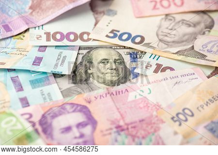 Photo Of Pile Of Ukrainian Hryvnia Banknote And One Hundred Dollar Banknote In The Middle