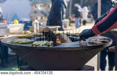 Smelt Fish Is Fried On A Large Grill During The Fish Festival In Svetlogorsk Raushen, Region, Russia