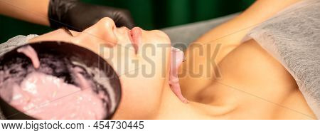 Beautiful Young Caucasian Woman Receiving An Alginic Mask To The Face In Beauty Salon. Facial Skin T