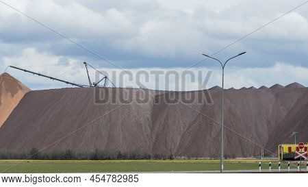 Giant Spreader Or Absetzer Machinery. A Large Dumper On A Landfill With Potash Ore. Extracting And M