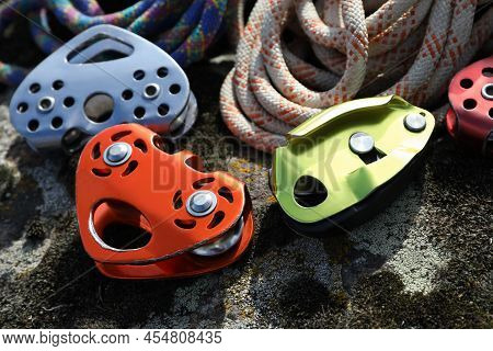 Different Belay Devices And Ropes On Rock, Closeup. Climbing Equipment