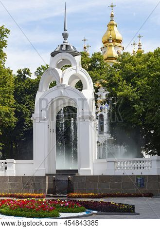 Mirror Stream Fountain In Park With Flowers And Green Trees, Myrrh-bearing Temple Of Kharkov In Back