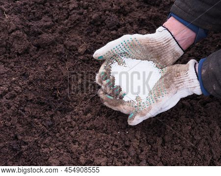 Potassium Nitrogen Fertilizers In Hands Of Farmer. Top View For Control Soil Quality Before Seed Pla