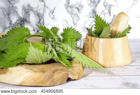 Fresh Nettle In A Wooden Mortar. Preparation Of Elixirs From Medicinal Herbs By Herbalists.