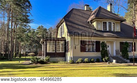 Latvia, Riga, April, 2022 - Private Residence With A Large Green Lawn In A Beautiful Garden Surround