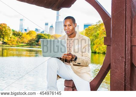 Business Man Working. Dressing In Cream Blazer, Collarless Sweater, White Pants, Wearing A Wristwatc