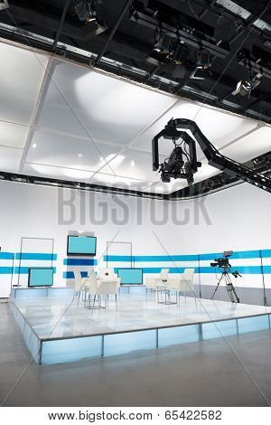 Television studio with jib camera and lights - camera on a crane. Shallow depth of field - focus on camera 