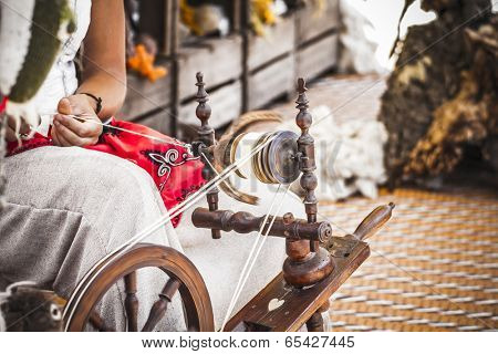 distaff, woman spinning yarn on an old spinning wheel