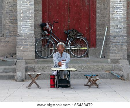 Inchuan, Inner Mongolia - Jul 6, 2011: Chinese Fortune Teller Sitting At The Entrance To A Buddhist