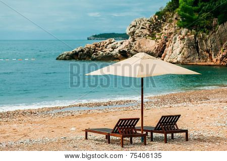 Two sunbeds  and umbrella at luxury beach resort