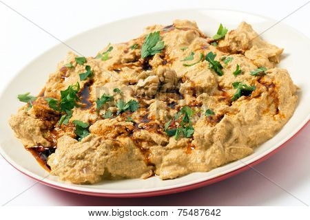 Traditional homemade Ottoman circassian chicken, shredded meat in walnut sauce, drizzled with walnut oil coloured with paprika