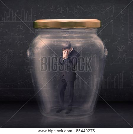 Business man closed into a glass jar concept on background