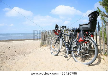 Bicycles leaning on fence by the beach