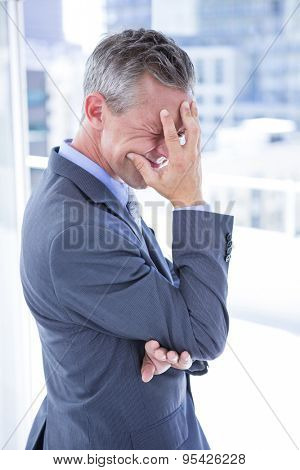 Troubled businessman holding his head in the office