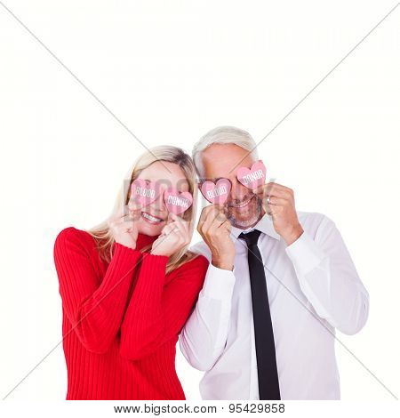 Silly couple holding hearts over their eyes against blood donor