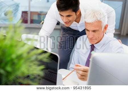 Two businessmen in fornt of computer in office