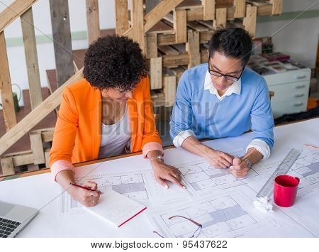Two desingers working on a project together in office