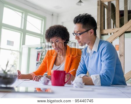 Two desingers working on a project together in office