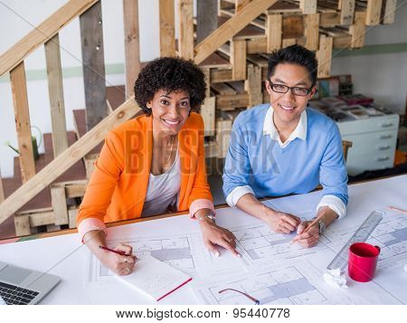 Two desingers working on a project together in office