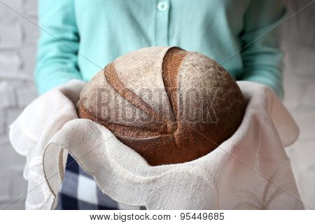Woman holding tasty fresh bread, close up