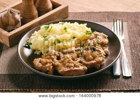 Pork tenderloin cooked in onion sauce served with mashed potatoes.