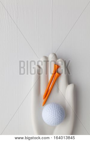 Detail of artifical hand with golf equipments - Flat Lay Photography