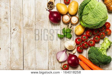 Healthy food background. Healthy food concept with fresh vegetables and ingredients for cooking. Top view with copy space. Wooden background.