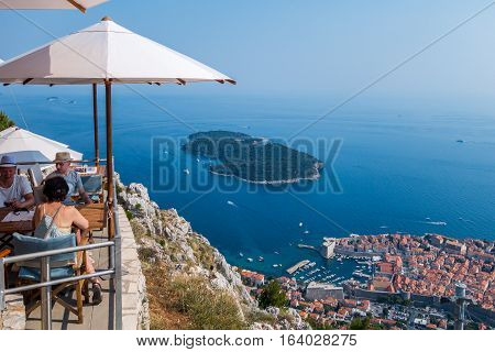 People in a restaurant above Dubrovnik. 
Dubrovnik, Croatia - July 18, 2015: Two men and one woman in a restaurant on top of the mountain above Dubrovnik. 
Summer view of Dubrovnik.