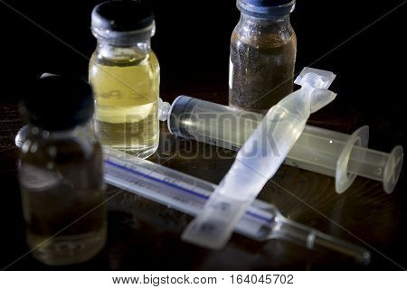 test tubes of flu vaccino with syringe and thermometer