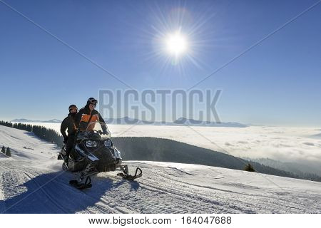 People driving snowmobile for a ride high in the mountains Bukovel ski resort Ukraine December 2016.